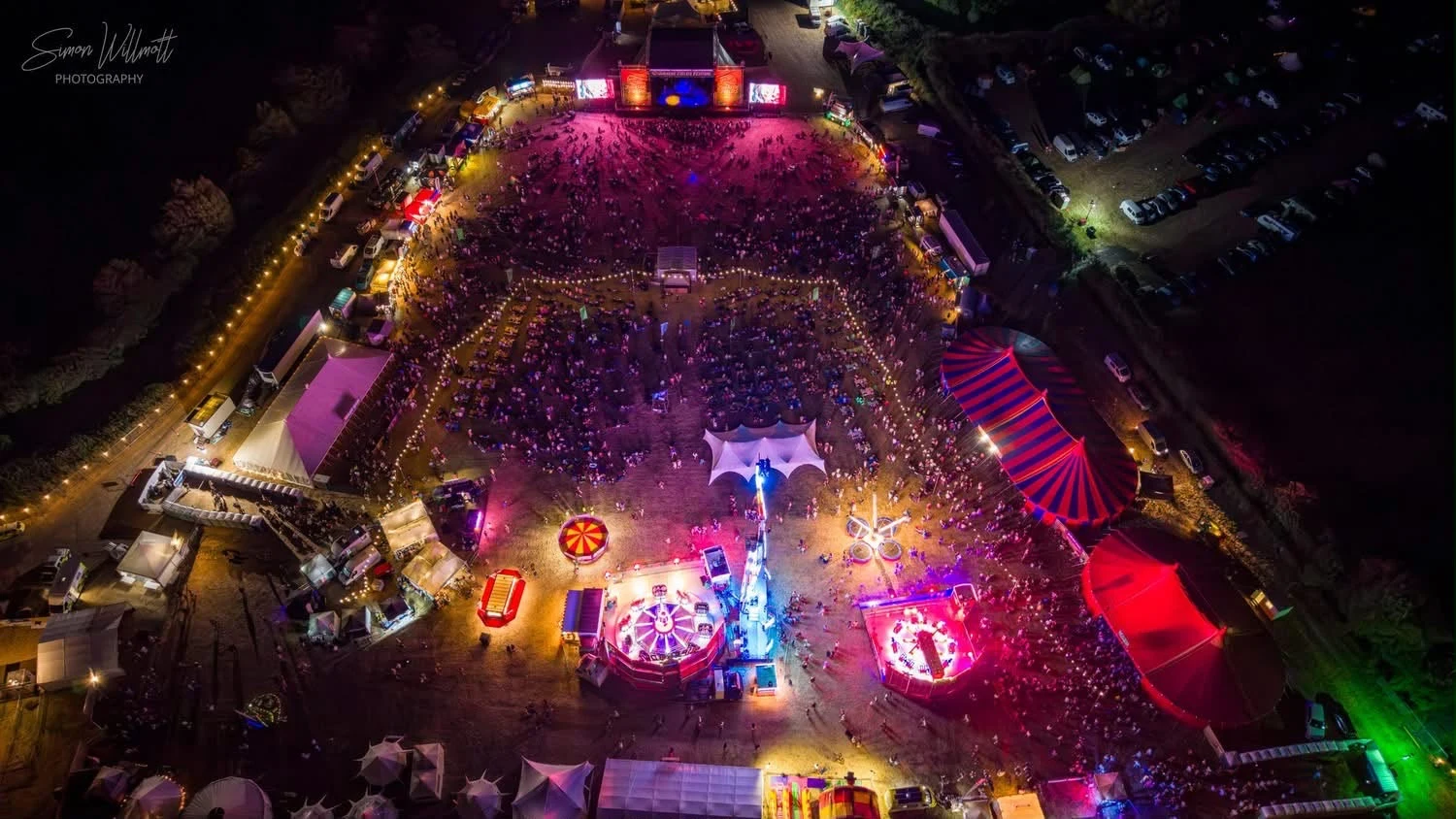 Aerial view of the illuminated Poole Marina Festival stage and audience
