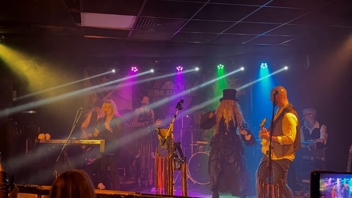Fleetwood Mad singers and guitarist sharing the stage as an audience member records the performance